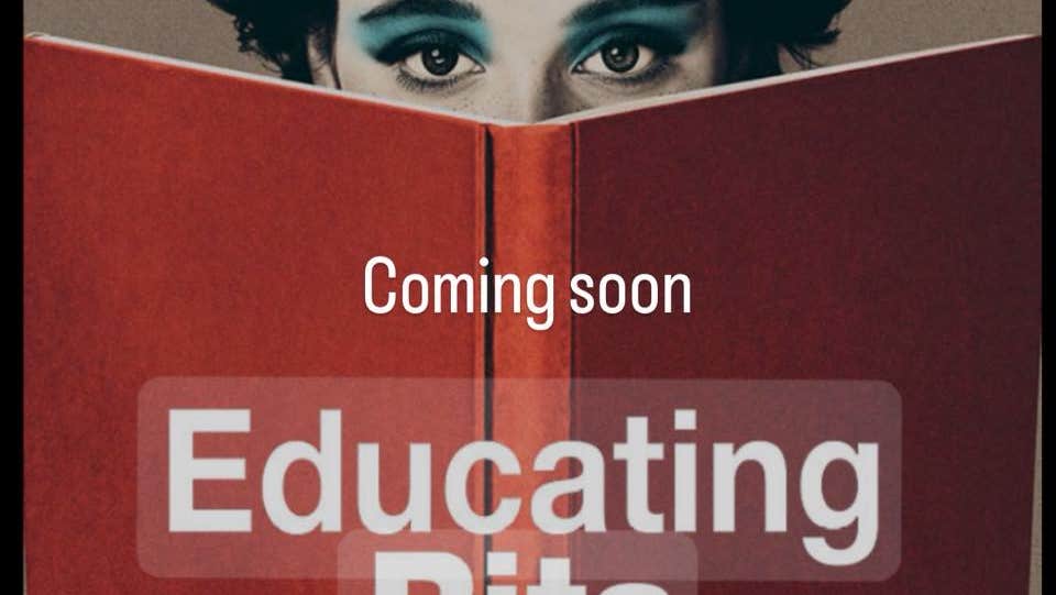 Image of large, open red covered book with woman's eyes appearing at the top