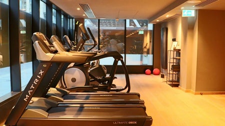 A bright fitness studio featuring treadmills and cardio equipment