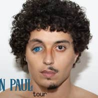 Clayton Pettet, known as Babymorocco, a man's head with curly dark hair and mismatched eyes, one brown the other blue and drooping down at the outer edge.