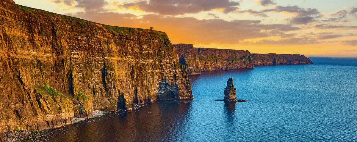 The Cliffs of Moher with an orange coloured sky above