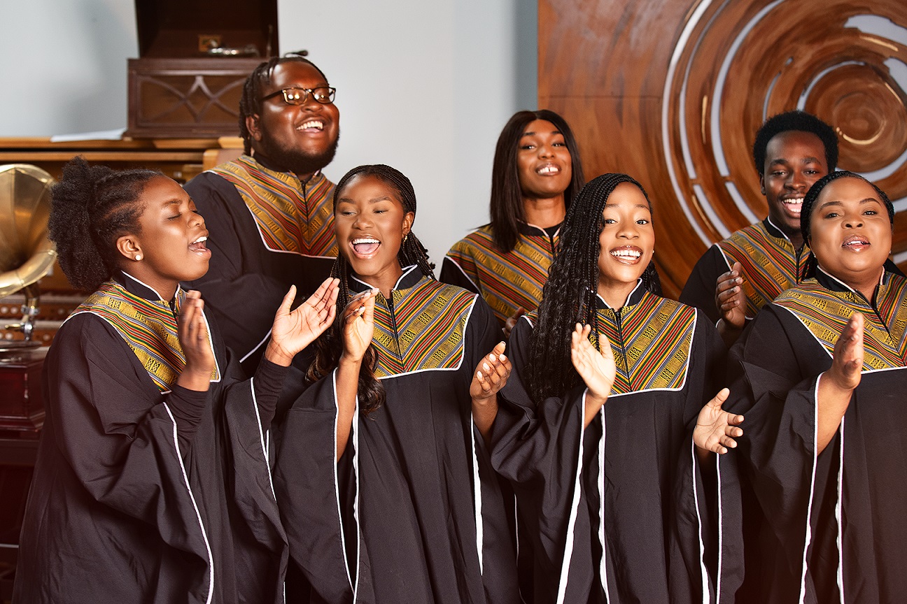 Seven members of the African Gospel Choir Dublin singing and clapping.