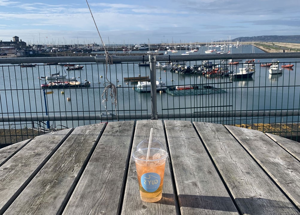 Guy's take away cup and beverage on a table over looking the harbour