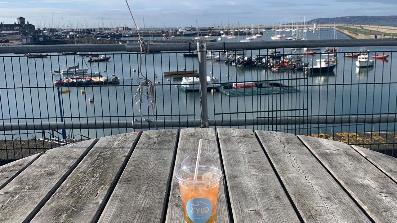Guy's take away cup and beverage on a table over looking the harbour