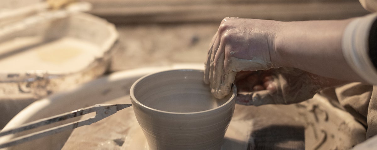 A close up of someone making pottery