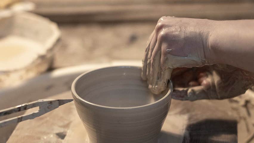 A close up of someone making pottery