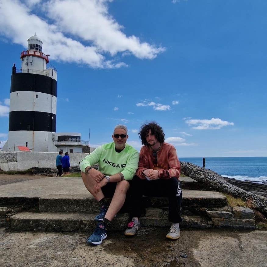 Baz Ashmawy and his son sitting in front of Hook Lighthouse in Wexford.