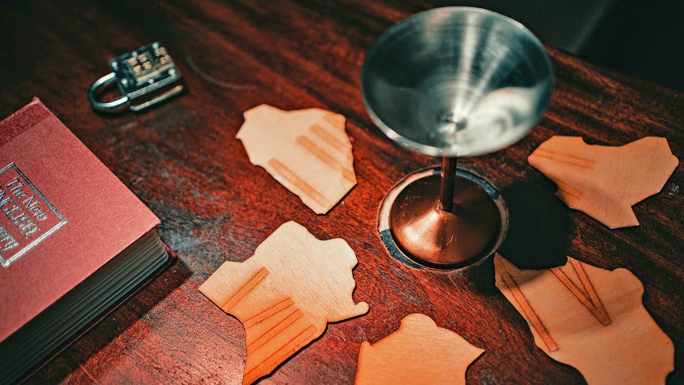 Inside Castlebar Escape Room with puzzle pieces a book a lock and a goblet on a table