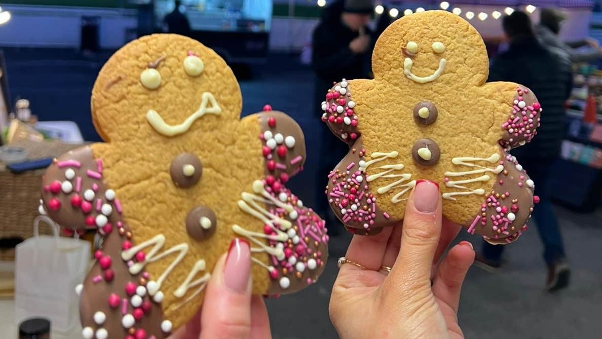Clonmel Christmas Market 2025, 2 hands holding up gingerbread men biscuits.