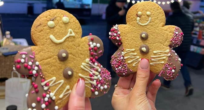Clonmel Christmas Market 2025, 2 hands holding up gingerbread men biscuits.