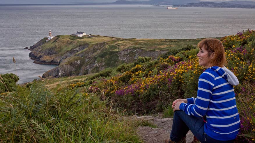A woman sitting down looking out at the stunning views of Howth Head.