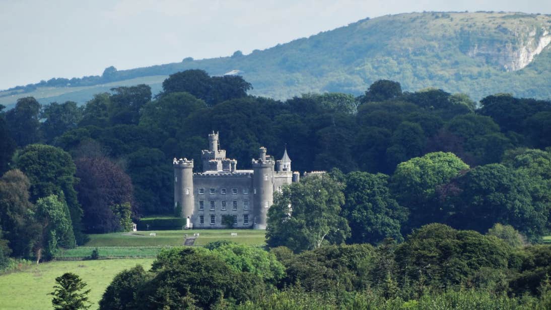Tullynally Castle surrounded by trees and green hills in County Westmeath