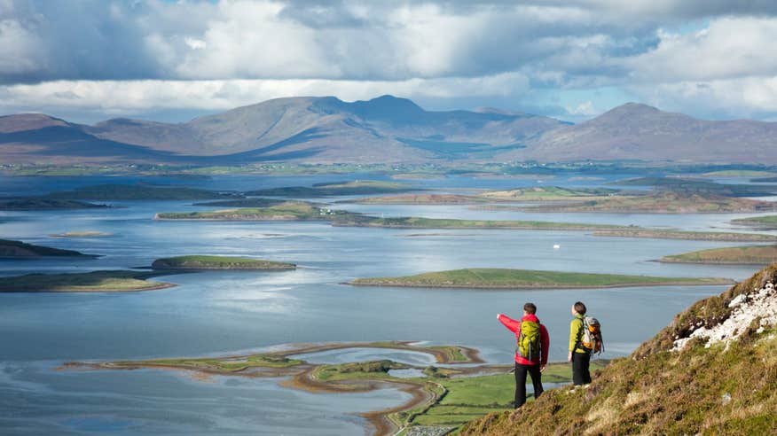 Two people overlooking Clew Bay from Croagh Patrick in Mayo