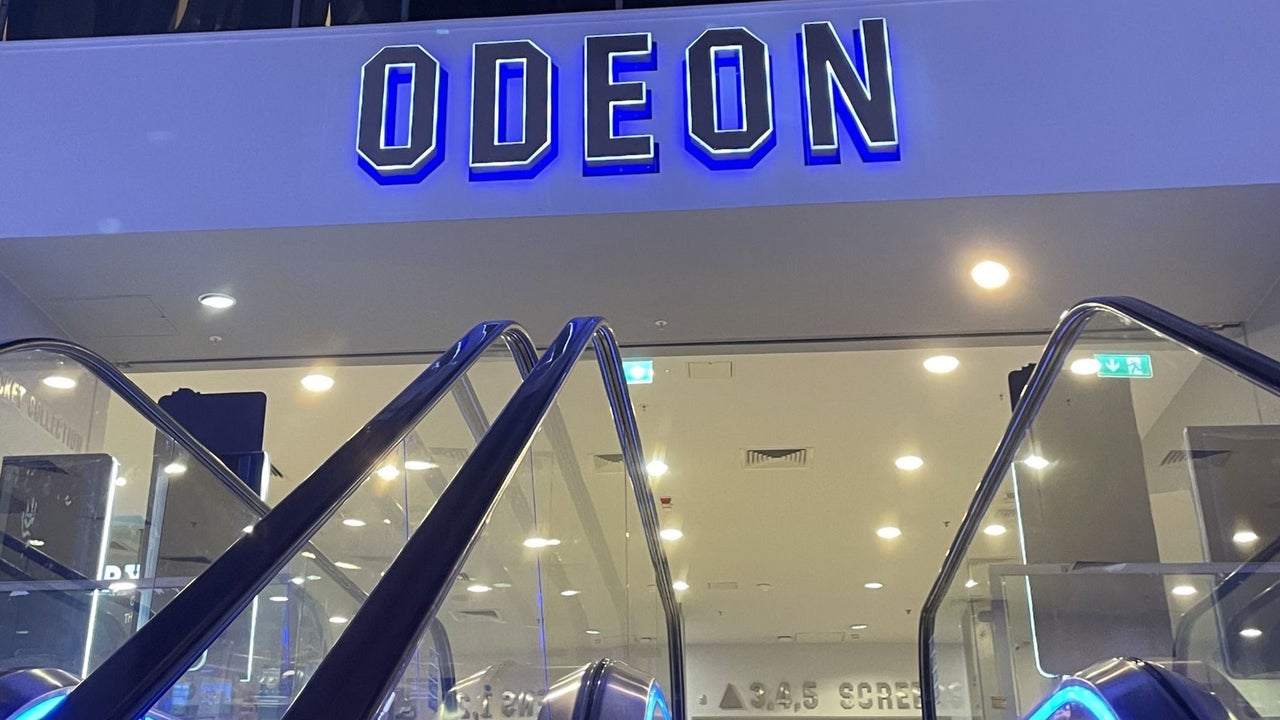 An Odeon sign at the top of an escalator
