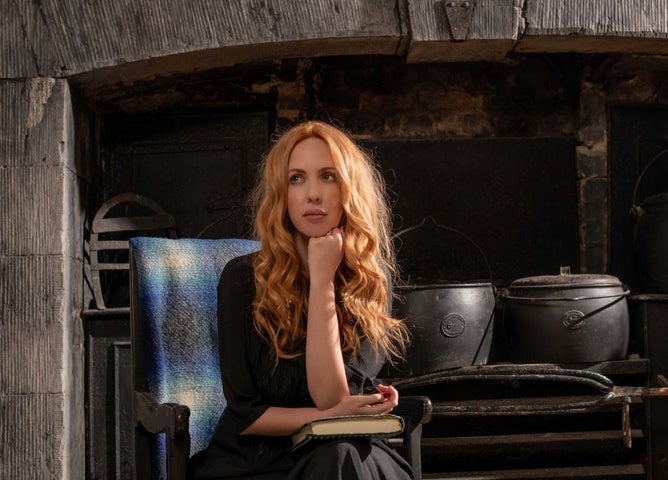 Lisa Lambe - Nightvisiting, The Hauling Home - a wistful looking woman with long wavy hair is resting her chin on raised left hand.