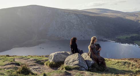 A scene from the tv series 'Vikings' showing two women looking down at Glendalough in county Wicklow.