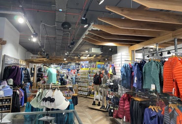 Shop floor with rows of different coloured clothes on hangers