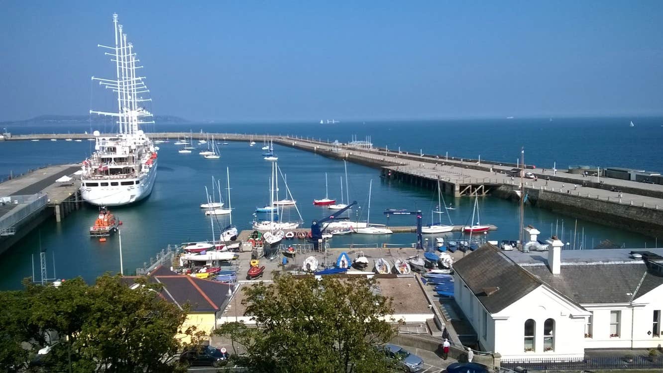 A view of a harbour with small boats and one large ship with tall masts