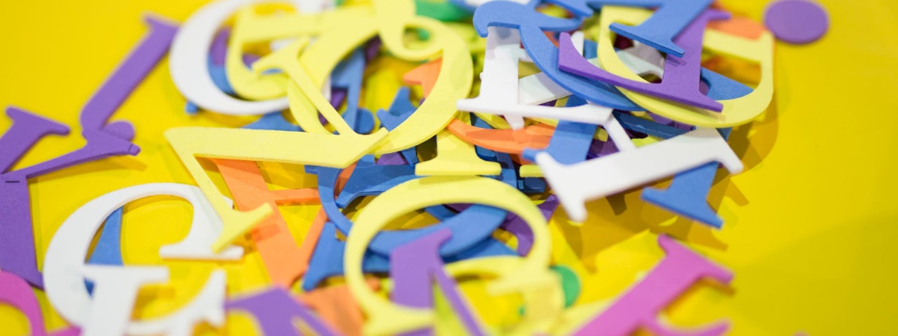 A pile of letters of different colours for use on a Sizzix die-cutting machine.