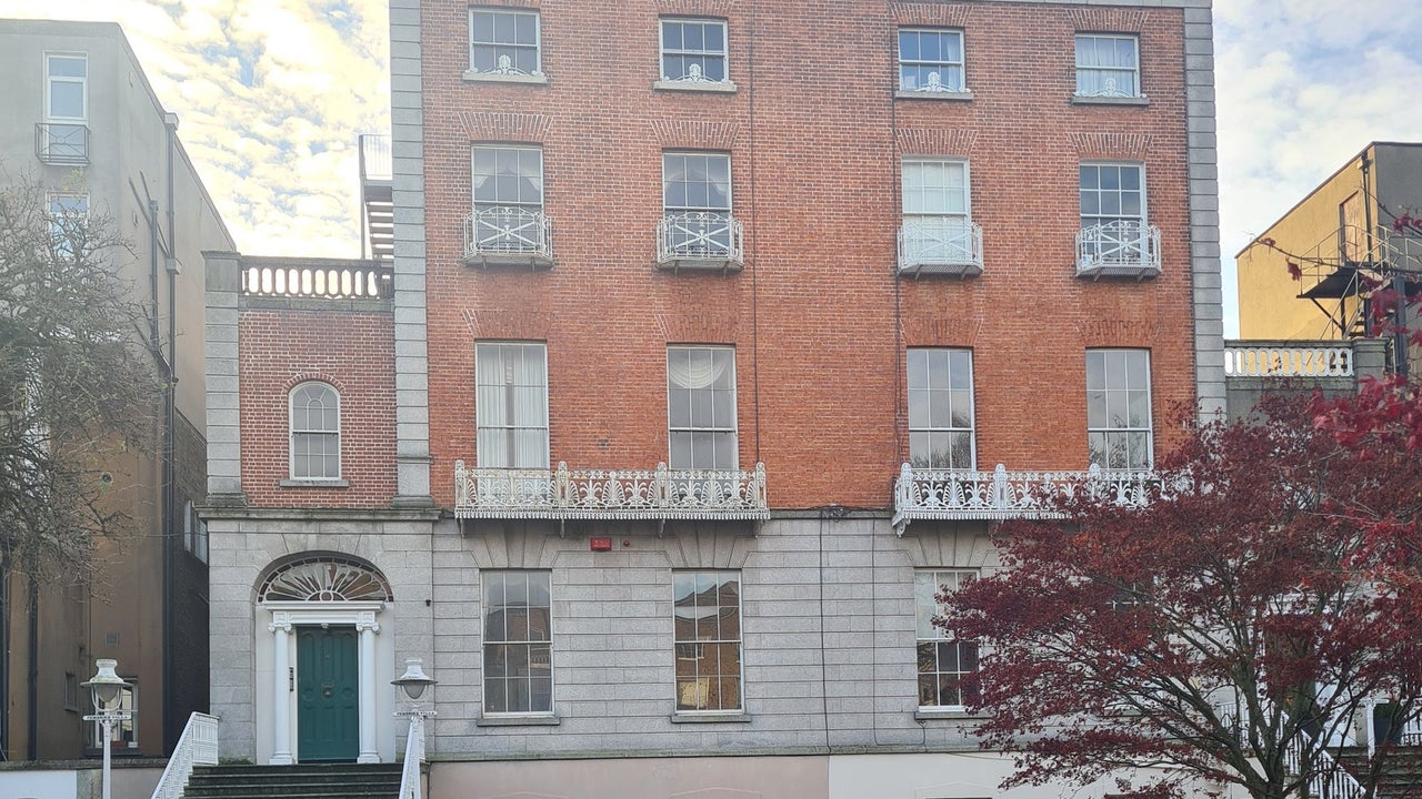 Two storey red bricked building on a city street