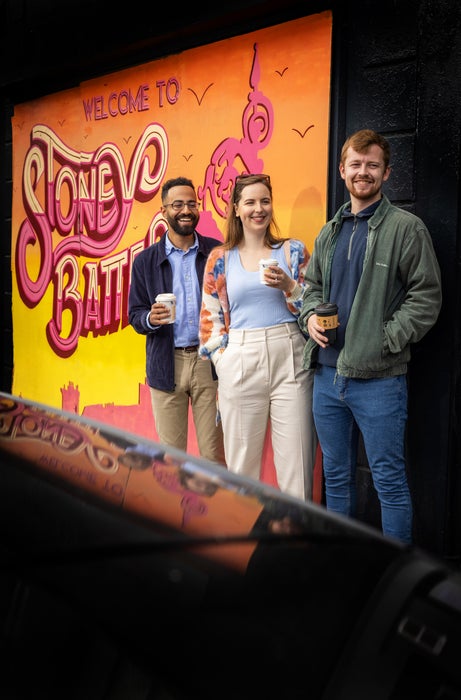 Three people standing beside a mural in Stoneybatter in Dublin city