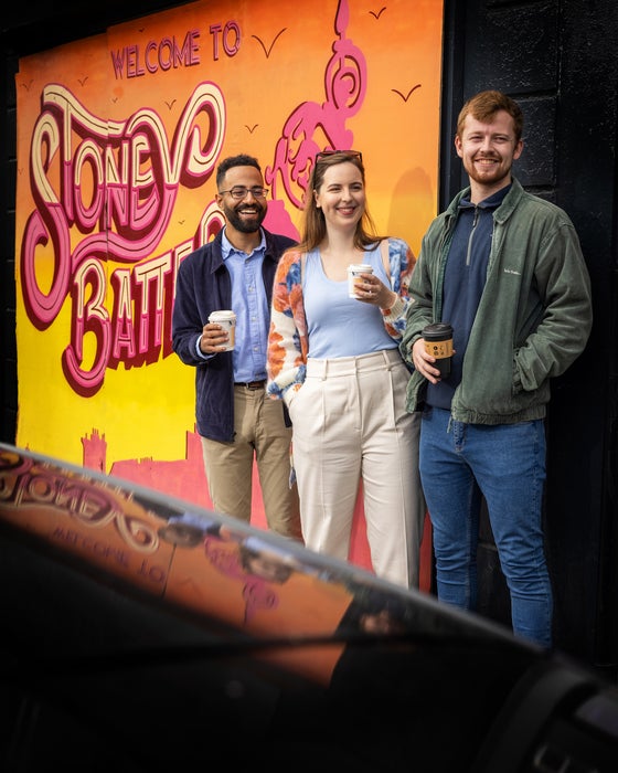 Three people standing beside a mural in Stoneybatter in Dublin city