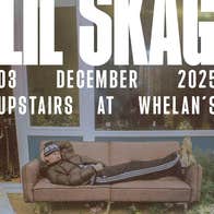 A man is laying on an old brown sofa in front of a building in a scruffy garden