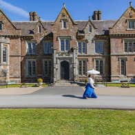Lady in costume walking in front of Wells House