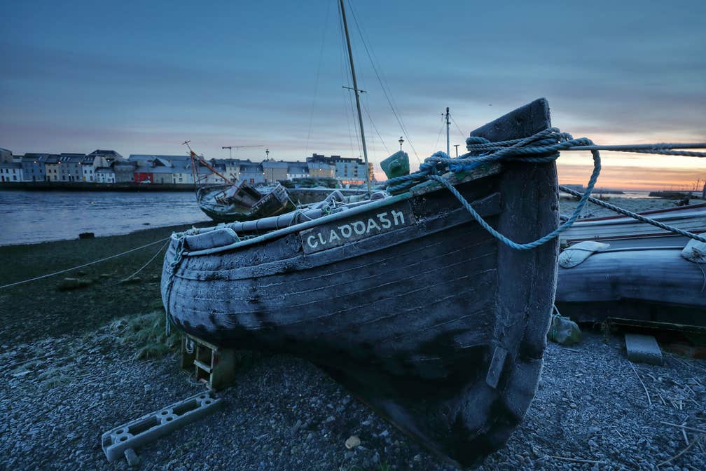 Image of a boat in the Claddagh, Galway City, with the Long Walk in the background