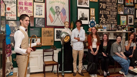 Guide leading a small group tour in a room full of memorabilia