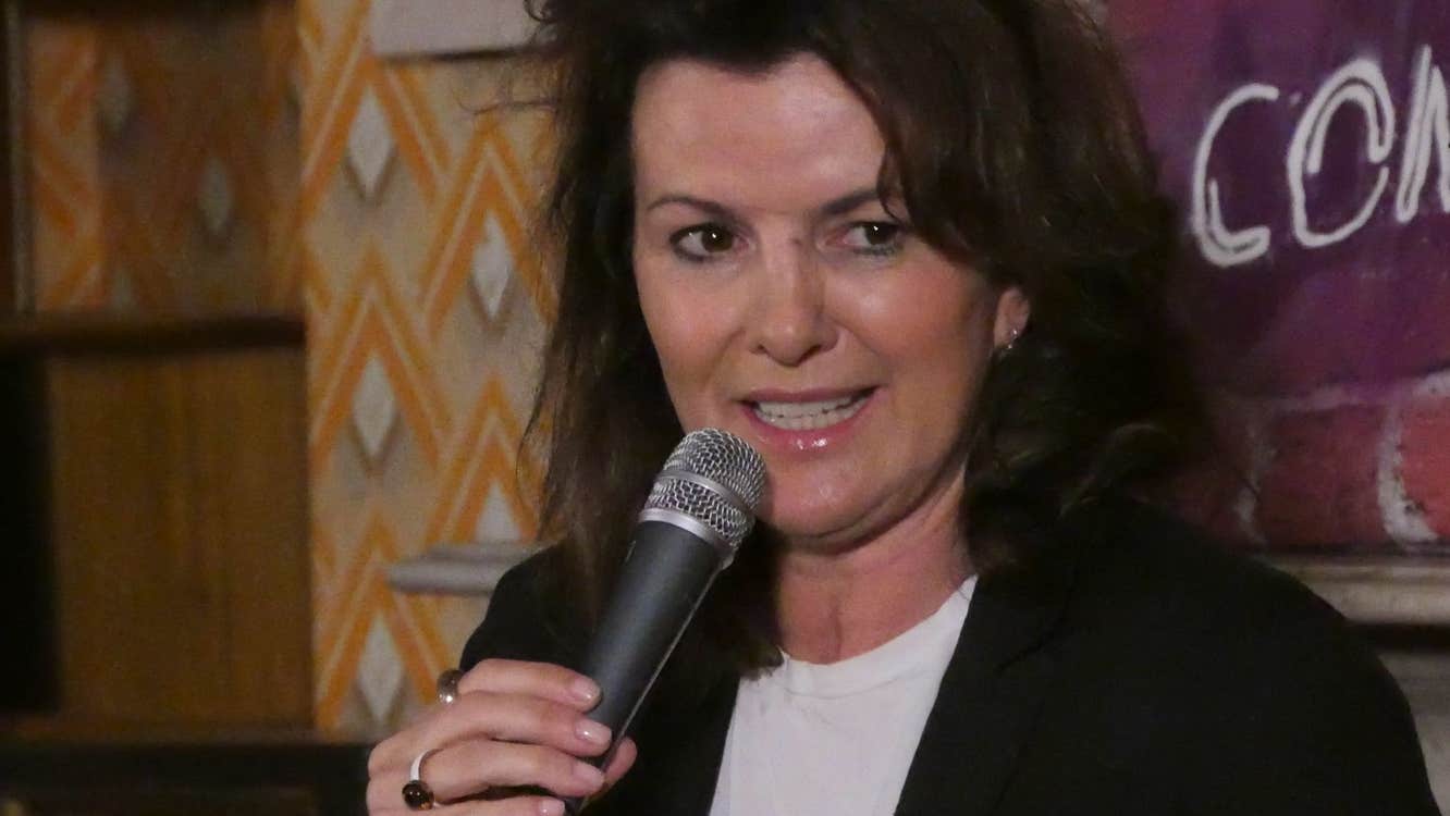 A woman comedian with a microphone in her hand