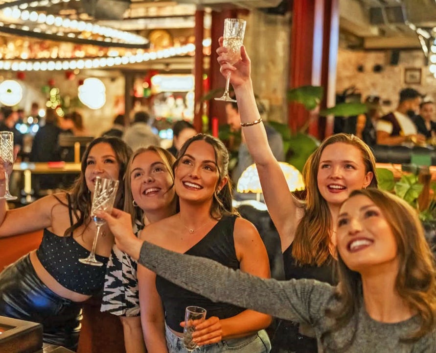 Flight Club Dublin group of women smiling and holding up cocktail glasses