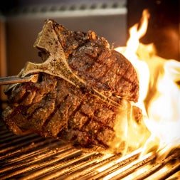 Flamed steak being cooked on a grill