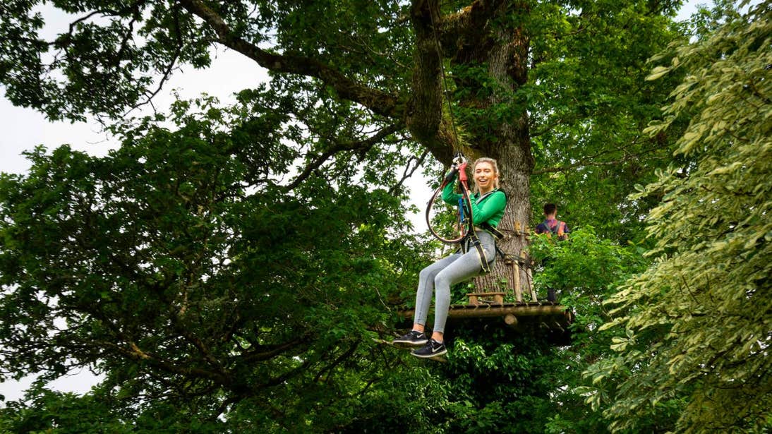 Girl on a zipline in a forest at Lough Key Forest Park and Adventure Centre, Co. Roscommon