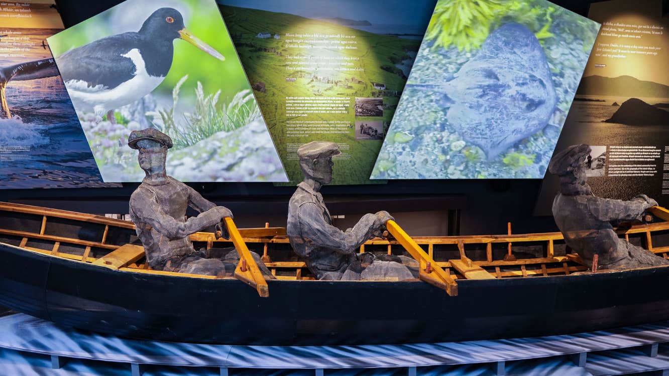 A model of curragh boat with three men rowing on display at the The Blasket Centre