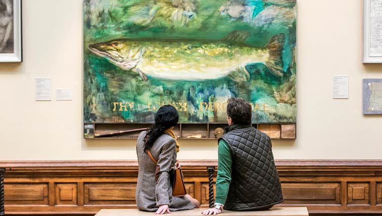 Two people enjoying a painting in Crawford Art Gallery in County Cork