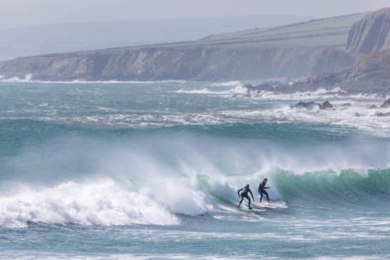 Two surfers on a wave at Garretstown Beach in Cork.