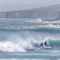 Two surfers on a wave at Garretstown Beach in Cork.