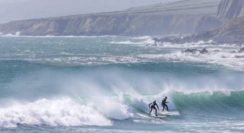 Two surfers on a wave at Garretstown Beach in Cork.