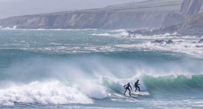 Two surfers on a wave at Garretstown Beach in Cork.