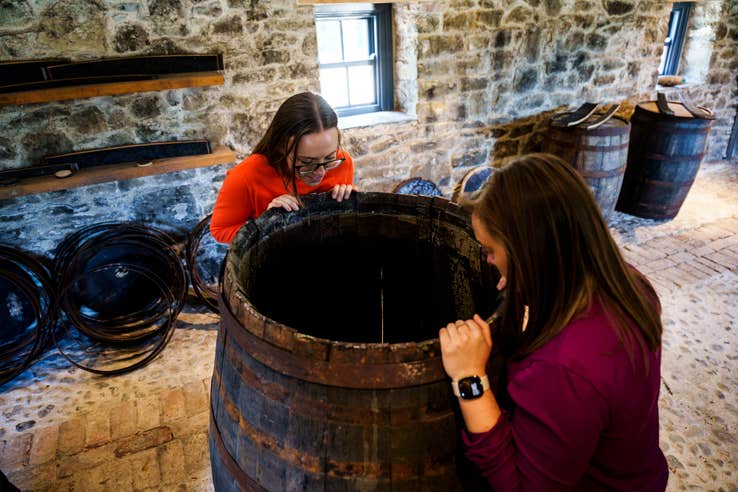 Two women looking at the old barrels in the Slane Distillery in Co Meath