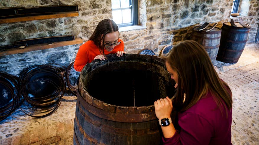 Two women looking at the old barrels in the Slane Distillery in Co Meath