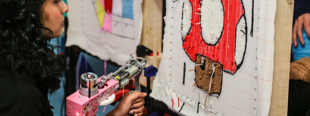 A guest enjoying herself tufting a Super Mario rug