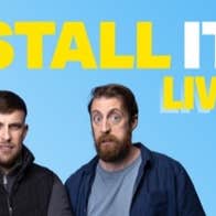 2 men standing, one looking suprised