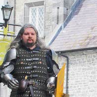 Knight for Hire Kilkenny guide in armour in front of grey stone building