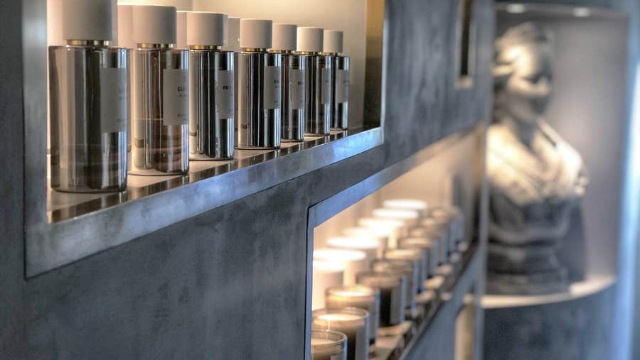 Bright modern shelving with rows of perfumes and candles on display