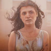 A disheveled young girl with an distraught expression, covered in dust.