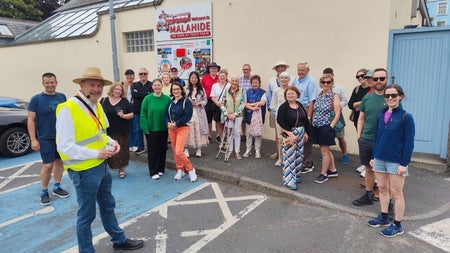 A group of people standing and their tour guide with Malahide Historical Tours