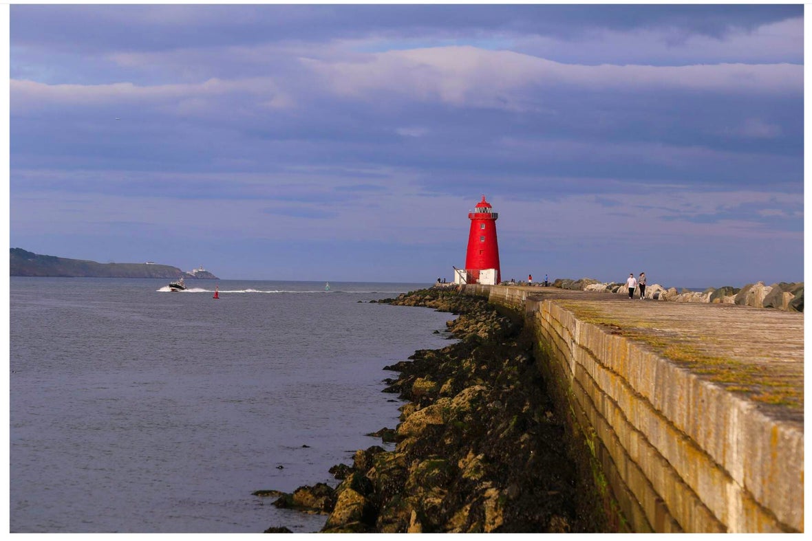 A wide view of Poolbeg Lighthouse on the pier.