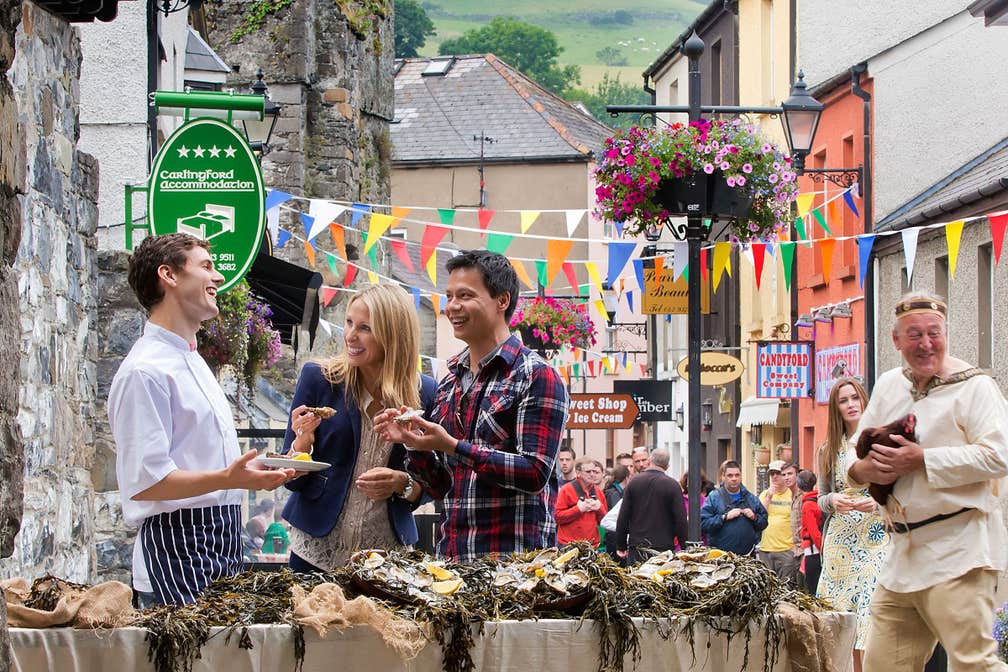 Friends tasting oysters at the Carlingford Oyster Festival, Carlingford, County Louth