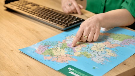 A genealogy researcher identifies an ancestral location on a map of Ireland. Consultations at the Irish Family History Centre help visitors connect family records with townlands, counties and ancestral homelands.